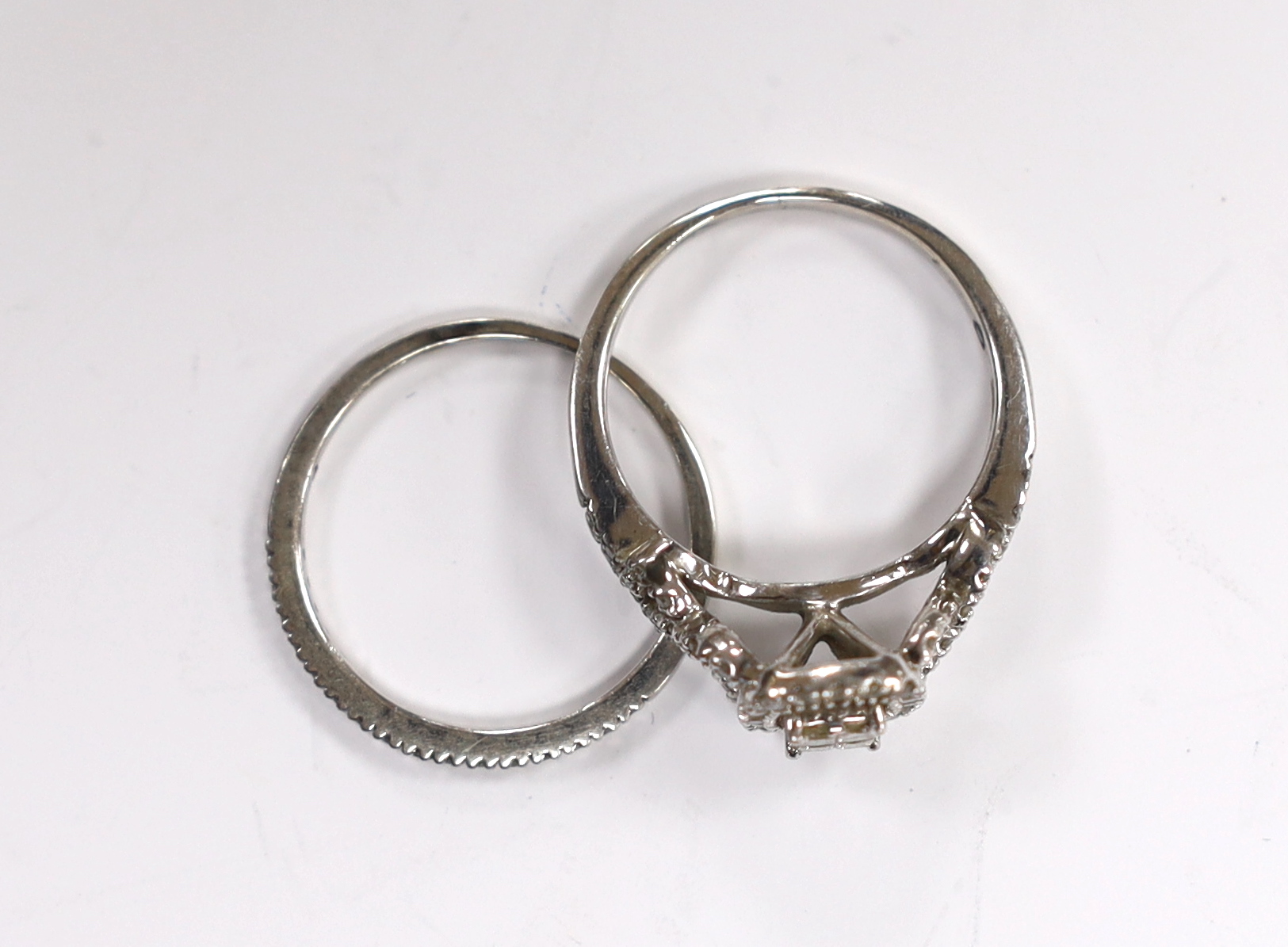 A modern white metal and diamond set cluster ring, with diamond set shoulders size N and a similar diamond chip set half eternity ring, engraved 'Plat', size N, gross weight 4.2 grams.